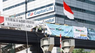 Pekerja menyelesaikan proyek pembangunan Jembatan Penyeberangan Orang (JPO) sekaligus Jembatan Penyeberangan Sepeda (JPS) Karet-Sudirman di Karet Tengsin, Jakarta Pusat, Sabtu (28/8/2021). [Suara.com/Alfian Winanto]