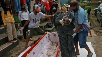 Sejumlah kerabat mengangkat jenazah keluarga untuk dibersihkan saat ritual Manene di Pangala, Kecamatan Rindingallo, Kabupaten Toraja Utara, Sulawesi Selatan, Jumat (27/8/2021). ANTARA FOTO / Sevianto Pakiding
