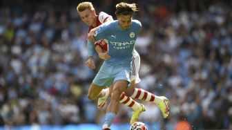 Gelandang Arsenal Martin Odegaard (kiri) bersaing dengan gelandang Manchester City Jack Grealish selama pertandingan sepak bola Liga Premier Inggris antara Manchester City dan Arsenal di Stadion Etihad, Manchester, Inggris, pada (28/8/2021). [Oli SCARFF / AFP]