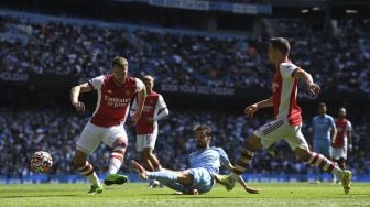 Gelandang Manchester City Bernardo Silva (tengah) melakukan tembakan selama pertandingan sepak bola Liga Premier Inggris antara Manchester City dan Arsenal di Stadion Etihad, Manchester, Inggris, pada (28/8/2021). [Oli SCARFF / AFP]