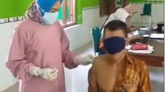 Kocak! Takut Jarum Suntik, Kakek Ini Tutupi Muka Pakai Masker hingga Dipegangi Polisi