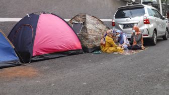 Pencari Suaka asal Afghanistan beraktivitas di depan tendanya di Kebon Sirih, Jakarta Pusat, Sabtu (28/8/2021). [Suara.com/Alfian Winanto]
