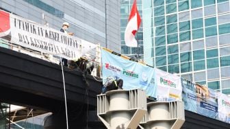 Pekerja menyelesaikan proyek pembangunan Jembatan Penyeberangan Orang (JPO) sekaligus Jembatan Penyeberangan Sepeda (JPS) Karet-Sudirman di Karet Tengsin, Jakarta Pusat, Sabtu (28/8/2021). [Suara.com/Alfian Winanto]