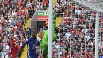 Penjaga gawang Liverpool Alisson Becker (tengah) tidak dapat menjangkau bola saat sundulan dari gelandang Chelsea Kai Havertz membuka skor dalam pertandingan sepak bola Liga Inggris antara Liverpool dan Chelsea di Anfield, Liverpool, Inggris, pada (28/8/2021). [Paul ELLIS / AFP]