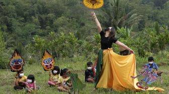 Seniman menampilkan tarian Peradaban Desa saat Festival Lima Gunung (FLG) XX di tengah persawahan Dusun Sudimoro, Baleagung, Grabag, Magelang, Jawa Tengah, Minggu (29/8/2021). [ANTARA FOTO/Anis Efizudin]