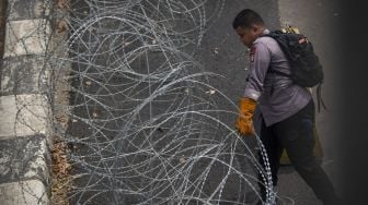 Polisi menata barikade kawat berduri dalam pengamanan sidang putusan banding Rizieq Shihab terkait perkara tes swab RS Ummi Bogor di Pengadilan Tinggi DKI Jakarta, Jakarta, Senin (30/8/2021). [ANTARA FOTO/Aditya Pradana Putra]