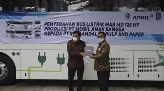 Founder PT Mobil Anak Bangsa (MAB) Jenderal TNI (Purn) Dr. Moeldoko (kanan) menyerahkan bus listrik MAB tipe MD 12E NF secara langsung kepada Presiden Direktur PT Riau Andalan Pulp and Paper Sihol Parulian Aritonang di samping bus listrik MAB tipe MD 12E NF yang terparkir di Gedung Sahid Sudirman Center, Jakarta, Selasa (31/8/2021). [Suara.com/Angga Budhiyanto]