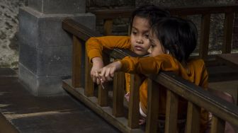 Anak kembar siam Al Putri Dewi Ningsih dan Al Putri Anugrah duduk di atas kursi roda yang didorong ayahnya di Bandung, Jawa Barat, Senin (30/8/2021). ANTARA FOTO/Novrian Arbi