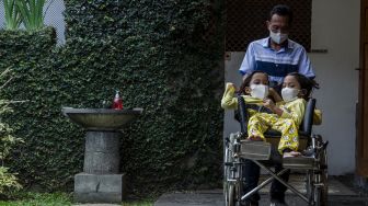 
Anak kembar siam Al Putri Dewi Ningsih dan Al Putri Anugrah duduk di atas kursi roda yang didorong ayahnya di Bandung, Jawa Barat, Senin (30/8/2021). ANTARA FOTO/Novrian Arbi