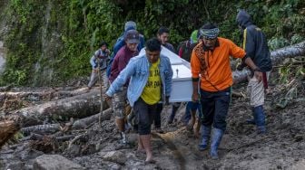 Warga mengangkat peti jenazah melintasi jalan yang tertimbun material longsoran di ruas Jalan Trans Palu-Kulawi di Desa Salua, Sigi, Sulawesi Tengah, Selasa (31/8/2021). ANTARA FOTO/Basri Marzuki