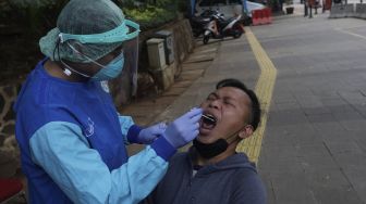 Petugas kesehatan melakukan tes usap (swab test) antigen dan PCR gratis di Terowongan Kendal, Menteng, Jakarta, Kamis (2/9/2021). [Suara.com/Angga Budhiyanto]