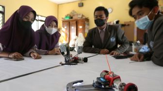 Pelajar mengoperasikan robot transpoter buatannya di MAN 1 Banyuwangi, Jawa Timur, Rabu (1/9/2021). ANTARA FOTO/Budi Candra Setya