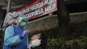 Petugas kesehatan melakukan tes usap (swab test) antigen dan PCR gratis di Terowongan Kendal, Menteng, Jakarta, Kamis (2/9/2021). [Suara.com/Angga Budhiyanto]