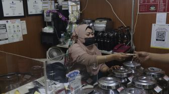 Penjual biji kopi melayani pembeli di Pasar Santa, Jakarta, Kamis (2/9/2021). [Suara.com/Angga Budhiyanto]