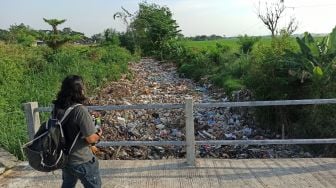 Waduh! Saluran Irigasi di Bekasi Tersumbat Sampah Ratusan Meter, Baunya ke Mana-mana