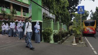 Pelajar bersiap menaiki Bus Sekolah Gratis usai mengikuti pembelajaran tatap muka (PTM) di SMK Negeri 15 Jakarta, Kebayoran Baru, Jakarta Selatan, Jumat (3/9/2021). [Suara.com/Angga Budhiyanto]