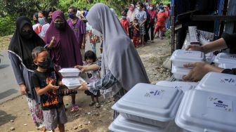 Seorang relawan memberikan nasi bungkus kepada warga di Rawalumbu, Bekasi, Jawa Barat, Jumat (3/9/2021). ANTARA FOTO