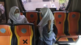 Pelajar menaiki Bus Sekolah Gratis usai mengikuti pembelajaran tatap muka (PTM) di SMK Negeri 15 Jakarta, Kebayoran Baru, Jakarta Selatan, Jumat (3/9/2021). [Suara.com/Angga Budhiyanto]