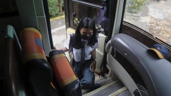 Pelajar menaiki Bus Sekolah Gratis usai mengikuti pembelajaran tatap muka (PTM) di SMK Negeri 15 Jakarta, Kebayoran Baru, Jakarta Selatan, Jumat (3/9/2021). [Suara.com/Angga Budhiyanto]