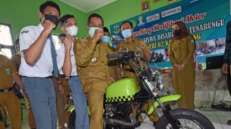 Wali Kota Serang Syafrudin (tengah) menaiki sepeda motor modifikasi hasil rancangan siswa tuna rungu di SKH Negeri 02 Serang Sodikin (kiri) dan Edo (kedua kiri), di Serang, Banten, Selasa (7/9/2021). ANTARA FOTO/Asep Fathulrahman