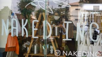 Karyawan toko merapikan barang dagangan yang akan dijual di Toko Naked Inc, Kemang, Jakarta Selatan, Kamis (9/9/2021). [Suara.com/Alfian Winanto]