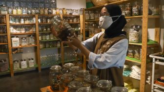 Karyawan toko merapikan barang dagangan yang akan dijual di Toko Naked Inc, Kemang, Jakarta Selatan, Kamis (9/9/2021). [Suara.com/Alfian Winanto]