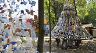 Relawan mengaitkan botol plastik bekas saat pembuatan instalasi Museum Plastik di Ecological Observation and Wetlands Conservation (Ecoton) di Gresik, Jawa Timur, Kamis (9/9/2021).  ANTARA FOTO/Zabur Karuru