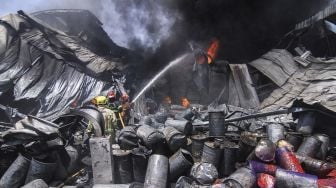 Petugas damkar berusaha memadamkan api yang membakar sebagian gudang di Pabrik Karung, Sukatani, Depok, Jawa Barat, Jumat (10/9/2021).  ANTARA FOTO/Asprilla Dwi Adha
