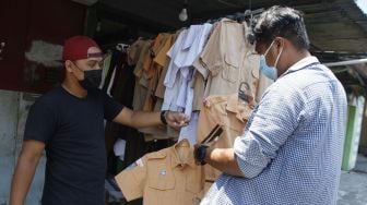 Pengunjung memilih baju seragam sekolah bekas pakai yang dijual di kawasan Gilingan, Solo, Jawa Tengah, Jumat (10/9/2021). [ANTARAFOTO/Maulana Surya]