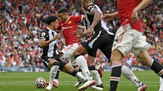 Gelandang Manchester United Jesse Lingard melewati pertahanan Newcastle untuk mencetak gol keempat mereka selama pertandingan sepak bola Liga Premier Inggris antara Manchester United dan Newcastle di Old Trafford, Manchester, Inggris, Sabtu (11/9/2021). [Oli SCARFF / AFP]