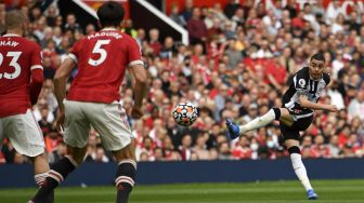 Gelandang Newcastle United Miguel Almiron (kanan) melakukan tembakan selama pertandingan sepak bola Liga Premier Inggris antara Manchester United dan Newcastle di Old Trafford, Manchester, Inggris, Sabtu (11/9/2021). [Oli SCARFF / AFP]