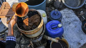 Warga menyaring air tanah yang akan digunakan untuk mencuci pakaian di Desa Sukaringin, Sukawangi, Kabupaten Bekasi, Jawa Barat, Jumat (10/9/2021).  ANTARA FOTO