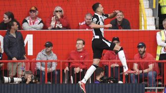 Gelandang Newcastle United Javier Manquillo merayakan setelah mencetak gol pertama mereka selama pertandingan sepak bola Liga Premier Inggris antara Manchester United dan Newcastle di Old Trafford, Manchester, Inggris, Sabtu (11/9/2021). [Oli SCARFF / AFP]