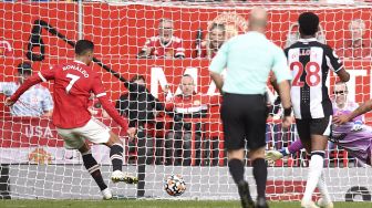 Striker Manchester United Cristiano Ronaldo (kiri) mencetak gol pembuka pada pertandingan sepak bola Liga Premier Inggris antara Manchester United dan Newcastle di Old Trafford, Manchester, Inggris, Sabtu (11/9/2021). [Oli SCARFF / AFP]