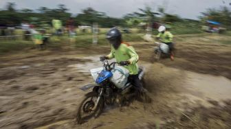 Sejumlah warga mengikuti balap sepeda motor gabah di lahan sawah milik warga di Desa Tegalsari, Kandeman, Kabupaten Batang, Jawa Tengah, Minggu (12/9/2021). [ANTARA FOTO/Harviyan Perdana Putra]