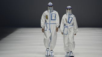 Model menampilkan kreasi untuk koleksi 'Heroes in Harm's Way' oleh Beijing Institute of Fashion Technology dan Dishang Group selama China Fashion Week di Beijing, Cina, pada (11/9/2021). [Jade GAO / AFP]