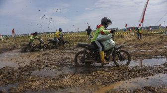 Sejumlah warga mengikuti balap sepeda motor gabah di lahan sawah milik warga di Desa Tegalsari, Kandeman, Kabupaten Batang, Jawa Tengah, Minggu (12/9/2021). [ANTARA FOTO/Harviyan Perdana Putra]