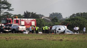 Sejumlah petugas melakukan evakuasi terhadap helikopter tipe Bell 429 PK-CAW milik Balai Besar Kalibrasi Fasilitas Penerbangan Kemeterian Perhubungan di landasan Bandara Budiarto, Curug, Kabupaten Tangerang, Banten, Senin (13/9/2021).  ANTARA FOTO/Fauzan