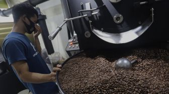 Pekerja melakukan proses pemanggangan biji kopi (roasting) di tempat produksi Dunia Kopi, Pasar Santa, Jakarta, Selasa (14/9/2021). [Suara.com/Angga Budhiyanto]