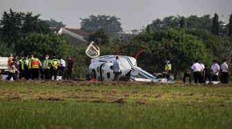 Sejumlah petugas melakukan evakuasi terhadap helikopter tipe Bell 429 PK-CAW milik Balai Besar Kalibrasi Fasilitas Penerbangan Kemeterian Perhubungan di landasan Bandara Budiarto, Curug, Kabupaten Tangerang, Banten, Senin (13/9/2021).  ANTARA FOTO/Fauzan