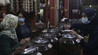 Pekerja melayani pembeli di kios Dunia Kopi, Pasar Santa, Jakarta, Selasa (14/9/2021). [Suara.com/Angga Budhiyanto]