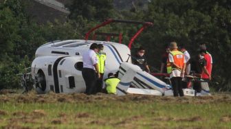 Sejumlah petugas melakukan evakuasi terhadap helikopter tipe Bell 429 PK-CAW milik Balai Besar Kalibrasi Fasilitas Penerbangan Kemeterian Perhubungan di landasan Bandara Budiarto, Curug, Kabupaten Tangerang, Banten, Senin (13/9/2021).  ANTARA FOTO/Fauzan