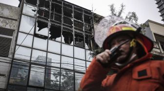 Petugas pemadam kebakaran berjalan usai memadamkan api yang membakar ruko di kawasan Glodok, Jakarta, Selasa (14/9/2021).  ANTARA FOTO/Dhemas Reviyanto