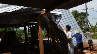 Warga memperbaiki rumah yang rusak akibat angin puting beliung di Desa Kedungrejo, Kecamatan Balerejo, Kabupaten Madiun, Jawa Timur, Rabu (15/9/2021). ANTARA FOTO/Siswowidodo
