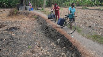 Warga membawa jeriken berisi air dengan sepeda saat mencari air bersih di Sawit, Ngerangan, Bayat, Klaten, Jawa Tengah, Selasa (14/9/2021). ANTARA FOTO/Aloysius Jarot Nugroho
