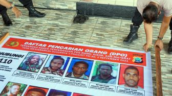 Polisi memasang baliho Daftar Pencarian Orang di Pelabuhan Laut Kota Sorong, Papua Barat, Kamis (16/9/2021). ANTARA FOTO/Olha Mulalinda