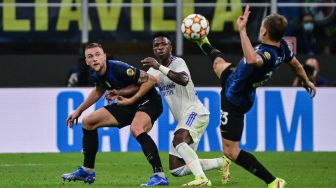 Gelandang Inter Milan Nicolo Barella (kanan) mengambil bola saat bek Inter Milan Milan Skriniar (kiri) dan penyerang Real Madrid dari Vinicius Junior selama pertandingan sepak bola Grup D Liga Champions antara Inter Milan melawan Real Madrid di Stadion di Stadion Giuseppe-Meazza, Milan, Italia, Kamis (16/9) dini hari WIB. MIGUEL MEDINA / AFP