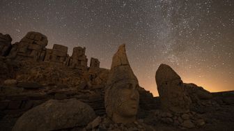 Patung kepala batu besar di situs arkeologi Gunung Nemrut di Adiyaman, Turki, Jumat (17/9/2021). [Yasin AKGUL / AFP]