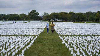 Warga berjalan melewati bendera putih di dekat Monumen Washington, Washington, DC, pada (16/9/2021). [MANDEL NGAN / AFP]