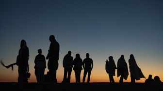 Wisatawan melihat matahari terbit di situs arkeologi Gunung Nemrut di Adiyaman, Turki, Jumat (17/9/2021). [Yasin AKGUL / AFP]